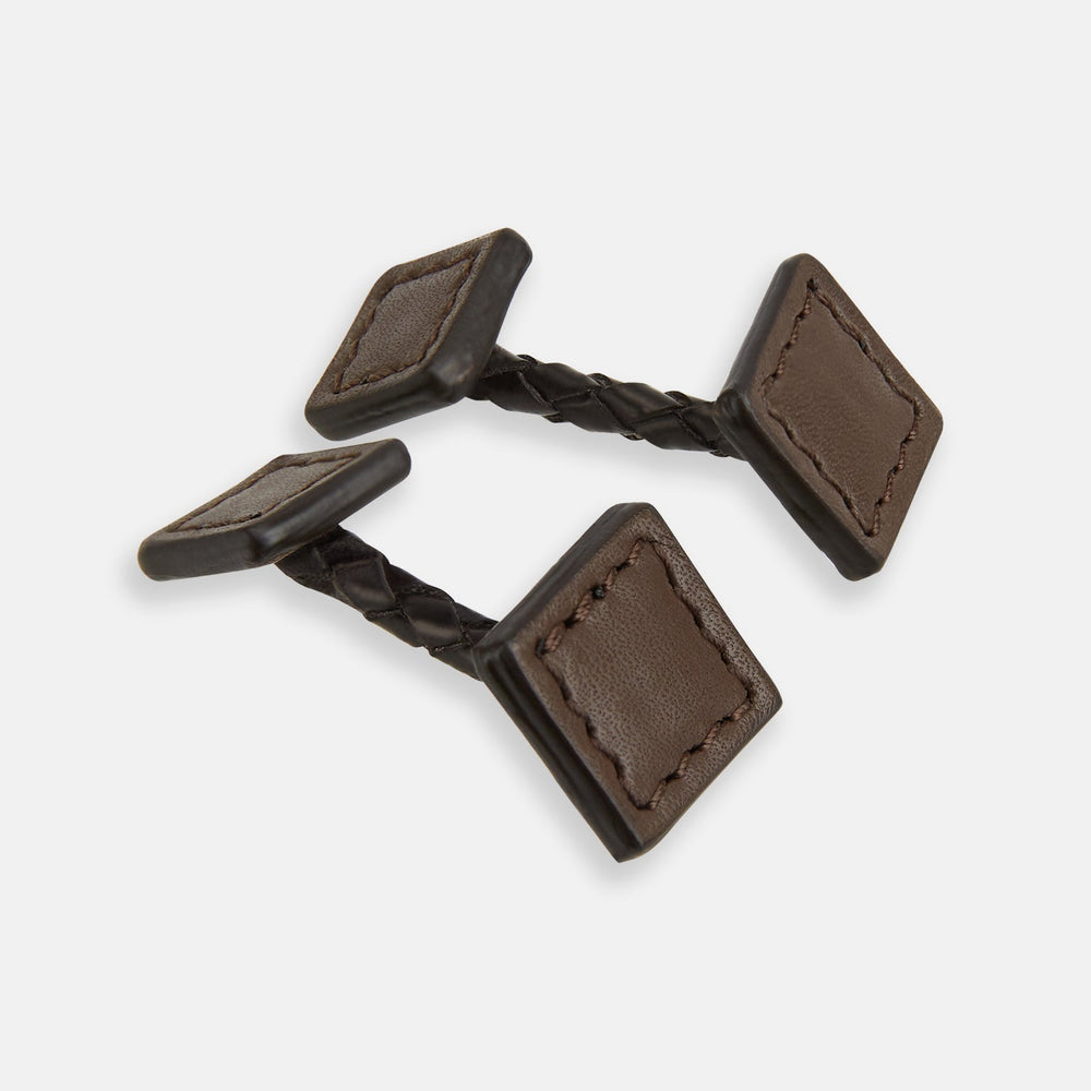 Turnbull & Asser’s Dark Chocolate Leather Cufflinks feature square Italian leather with stitched edges and braided links, perfect for men’s accessories, shown here on a white background.