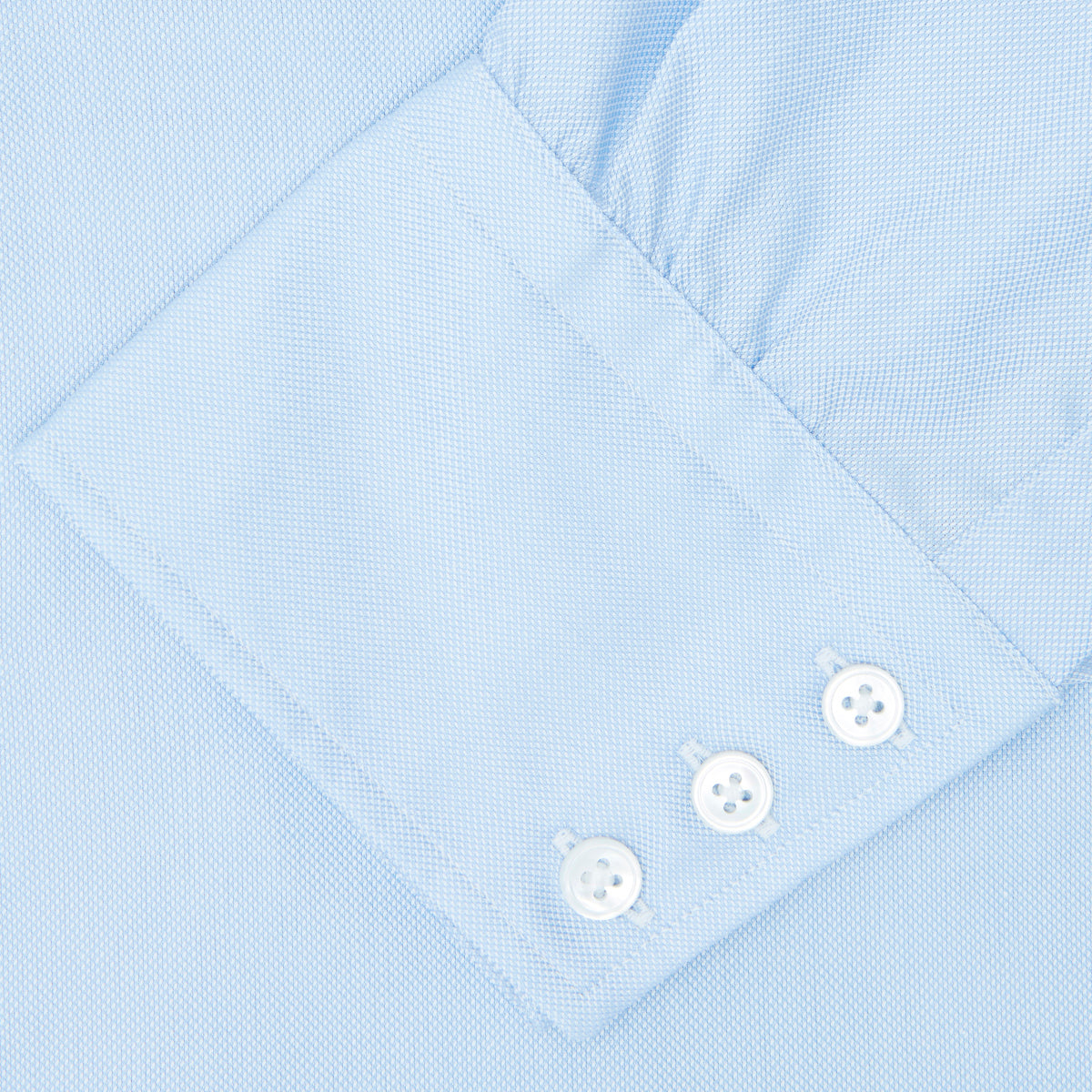 View 3 of product The Turnbull & Asser Light Blue Royal Oxford Cotton Shirt features a button-down collar, 3-button cuffs, and white buttons. Neatly folded with a visible inner label, it’s ideal to pair with a navy suit and displayed on a plain white background.