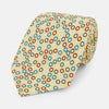 View 1 of product The Turnbull & Asser Multi-coloured Circle Yellow Silk Tie, crafted from fine English silk, features a vibrant pattern of multicoloured circles and is elegantly displayed rolled on a white background.
