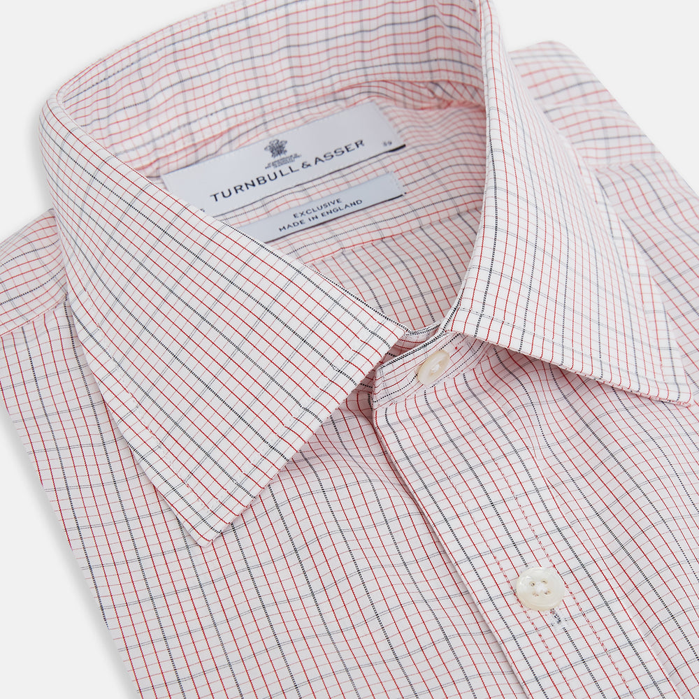 The Turnbull & Asser Red Micro Graph Check Mayfair Shirt is a long-sleeved, button-up Italian cotton shirt with a spread collar and buttoned cuffs, shown on a plain white background.