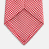 View 4 of product The Turnbull & Asser Red and White patterned silk tie, crafted from fine silk with a small geometric design, is elegantly rolled and displayed on a white background—a refined men’s accessory.