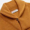 View 2 of product The Turnbull & Asser Gold Cashmere Shawl Neck Lytton Jumper, in ribbed knit with a horn button at the neckline, is stylishly laid flat on a white background.