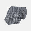View 1 of product The Turnbull & Asser White and Black Houndstooth Woven Silk Tie, shown rolled on a light grey background, adds a classic touch to any smart outfit.