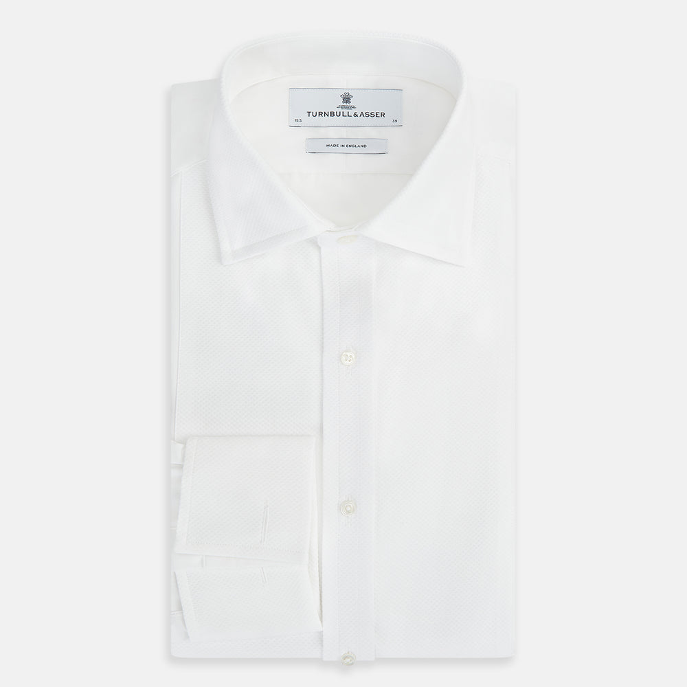 The Turnbull & Asser Tailored Fit White Marcella Front Shirt features a Kent Collar and double cuffs, shown laid flat on a white background. Perfect as a black tie shirt for formal events.