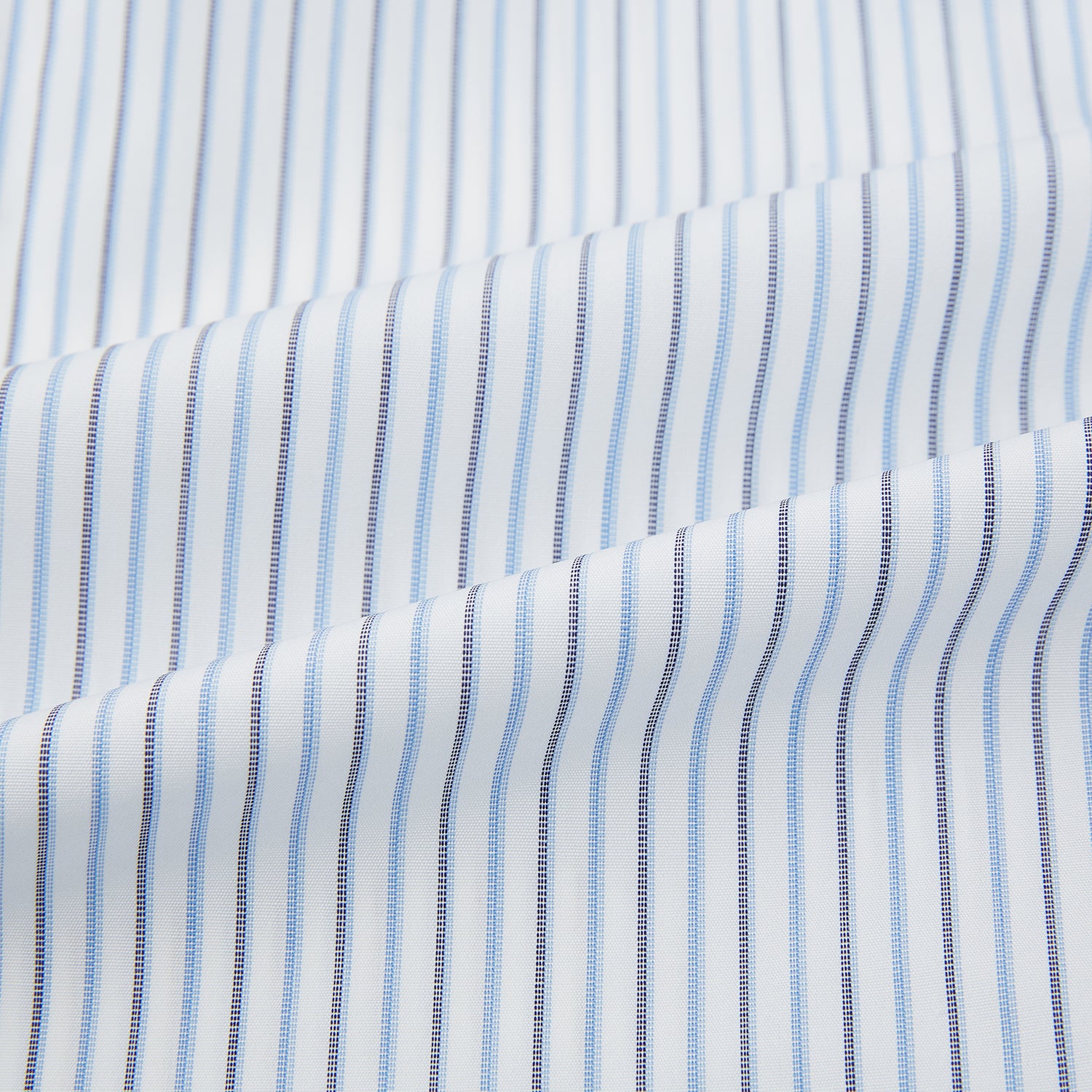 View 6 of product The Turnbull & Asser Navy and Blue Shadow Stripe Mayfair Shirt, featuring a classic T&A collar and buttoned cuffs, is laid flat on a white background.
