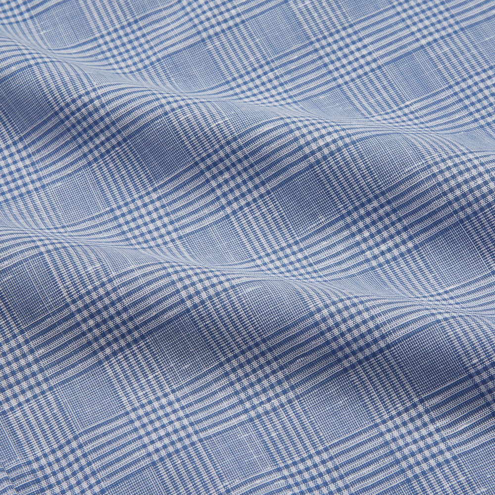 The Turnbull & Asser Pale Blue Multi Check Cotton Weekend Fit Williams Shirt features short sleeves, a pointed collar, single chest pocket, and premium Italian cotton with a subtle checkered pattern, shown on a white background.