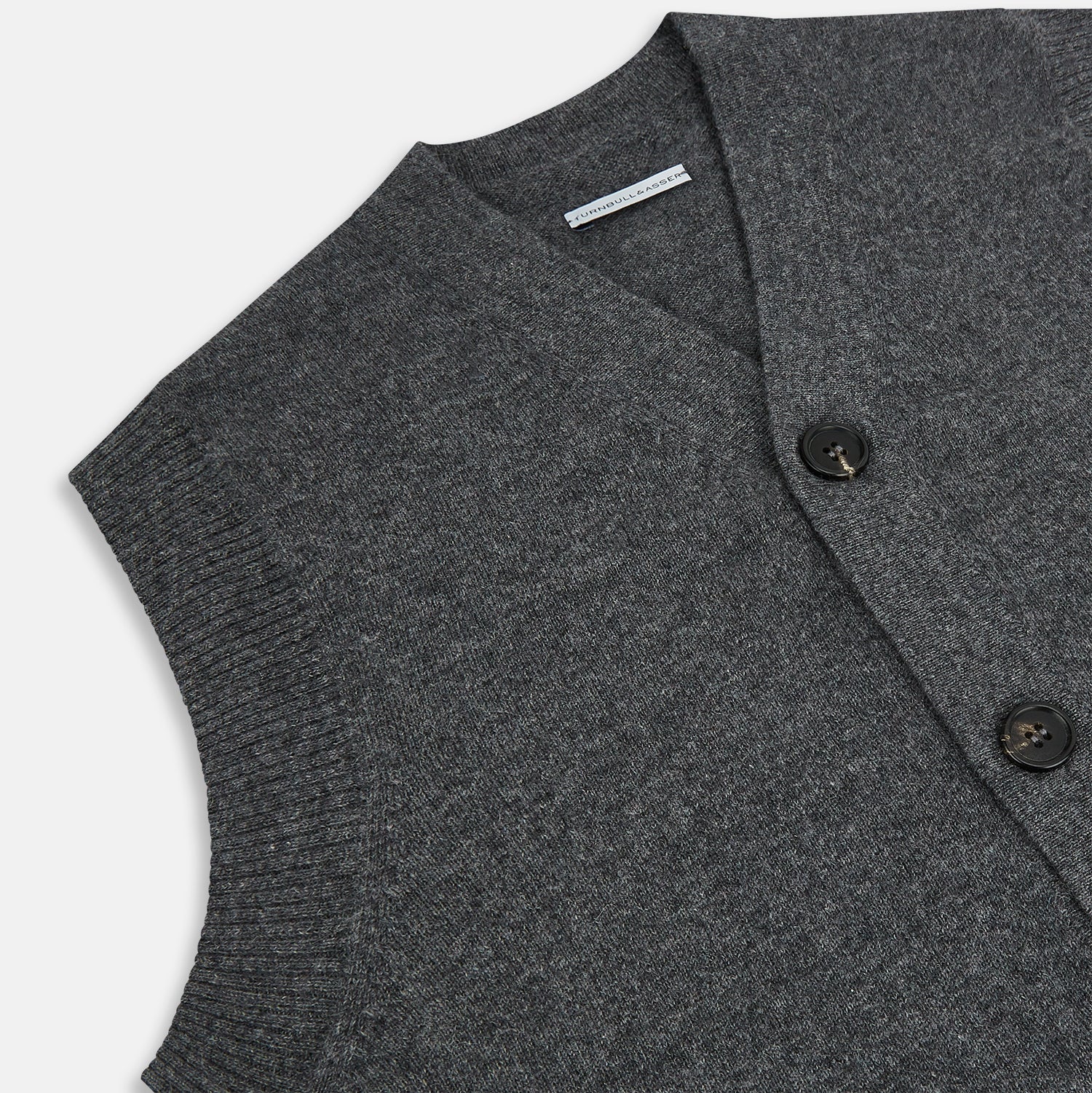 View 2 of product The Turnbull & Asser Charcoal Grey Cashmere Sleeveless Cardigan is a men's knit V-neck vest with ribbed collar, hem, and two front pockets, shown in dark grey melange against a white background.