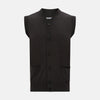 View 1 of product The Turnbull & Asser Dark Brown Merino V-Neck Sleeveless Cardigan features a button-up front and two pockets, styled as a men's sleeveless vest and shown on a plain white background.