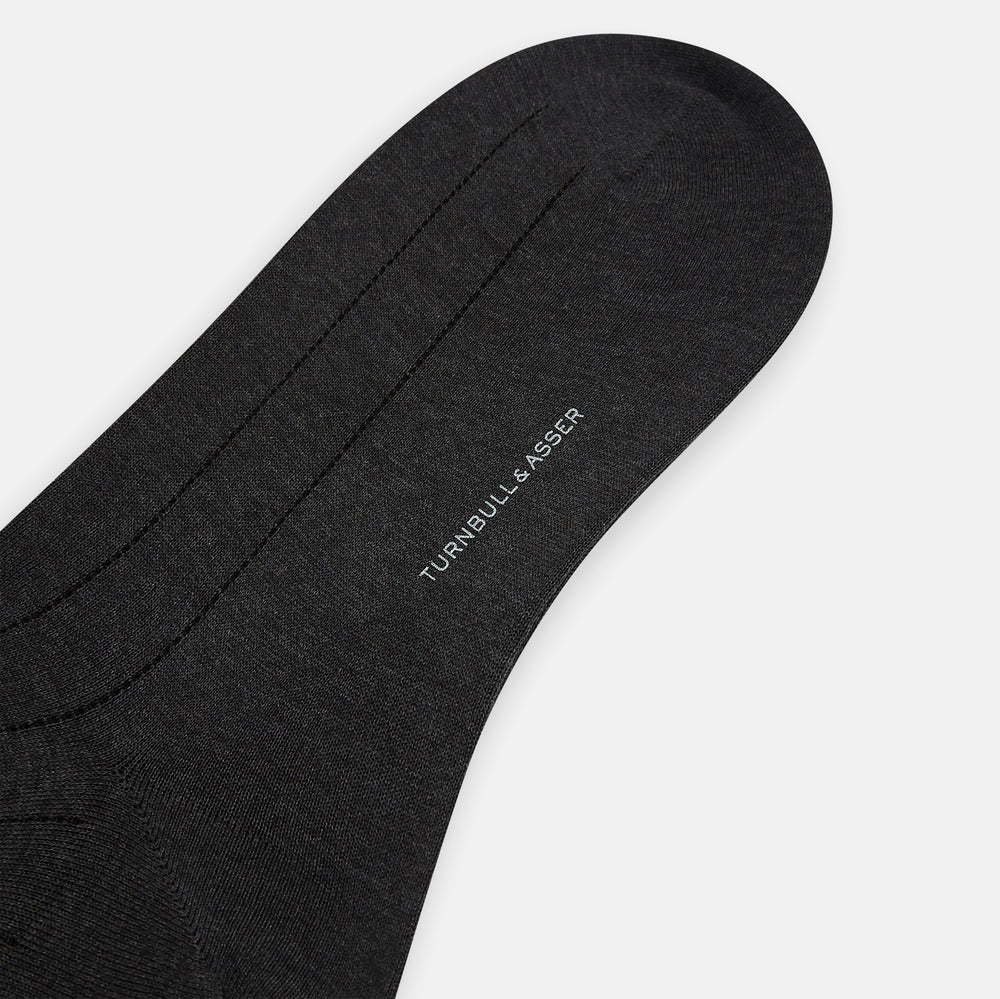 A single Charcoal/Brown Dash Striped Long Sock by Turnbull & Asser, made from mercerised Egyptian cotton, stands upright on a plain light background, showcasing its ribbed texture and fitted design.