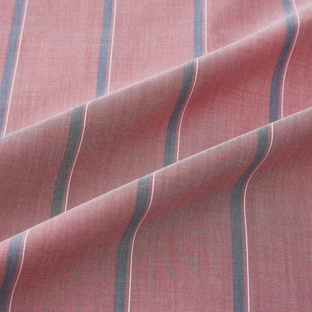 The Turnbull & Asser Red Track Stripe Westminster Shirt features British craftsmanship, a collar, pink base with vertical blue and white stripes, white buttons, and a pocket-free front for refined appeal.