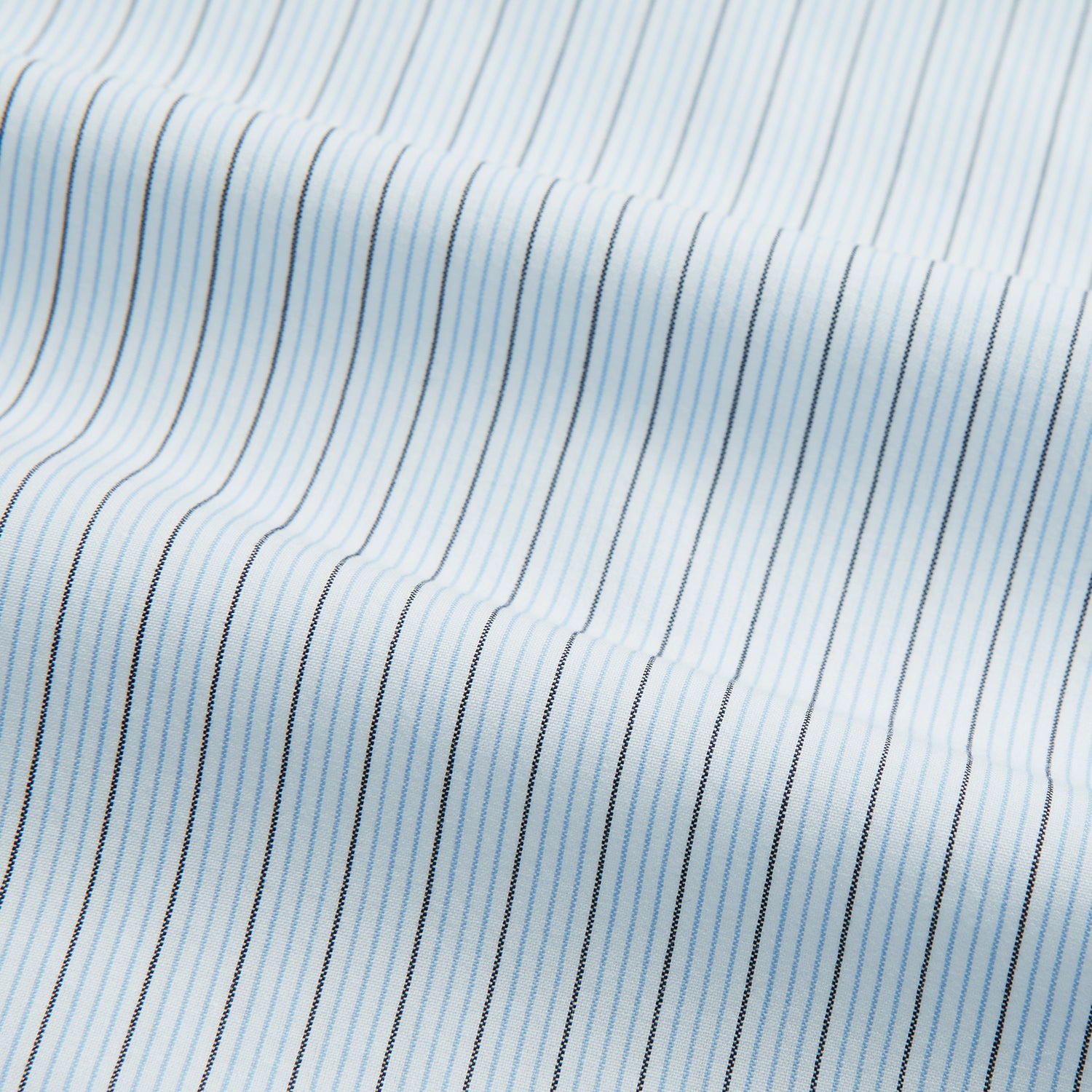 View 4 of product The Turnbull & Asser Hand Rolled Blue Multi Stripe Handkerchief features light blue cotton with thin black and white stripes, making it a refined accessory for the gentleman.