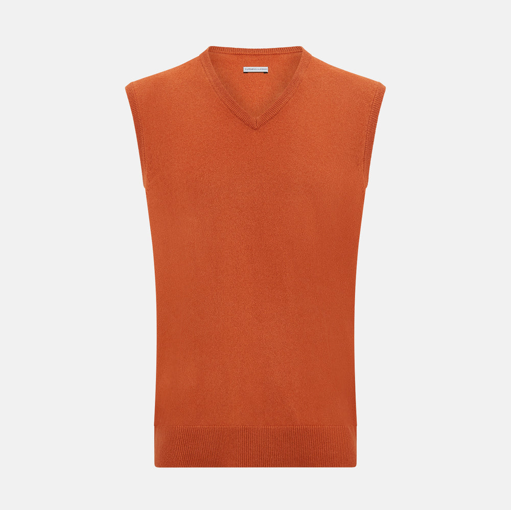 The Turnbull & Asser Orange Cashmere V-Neck Vest adds vibrant style to men’s fashion, featuring a ribbed hem and sleeveless design. Shown against a plain white background.