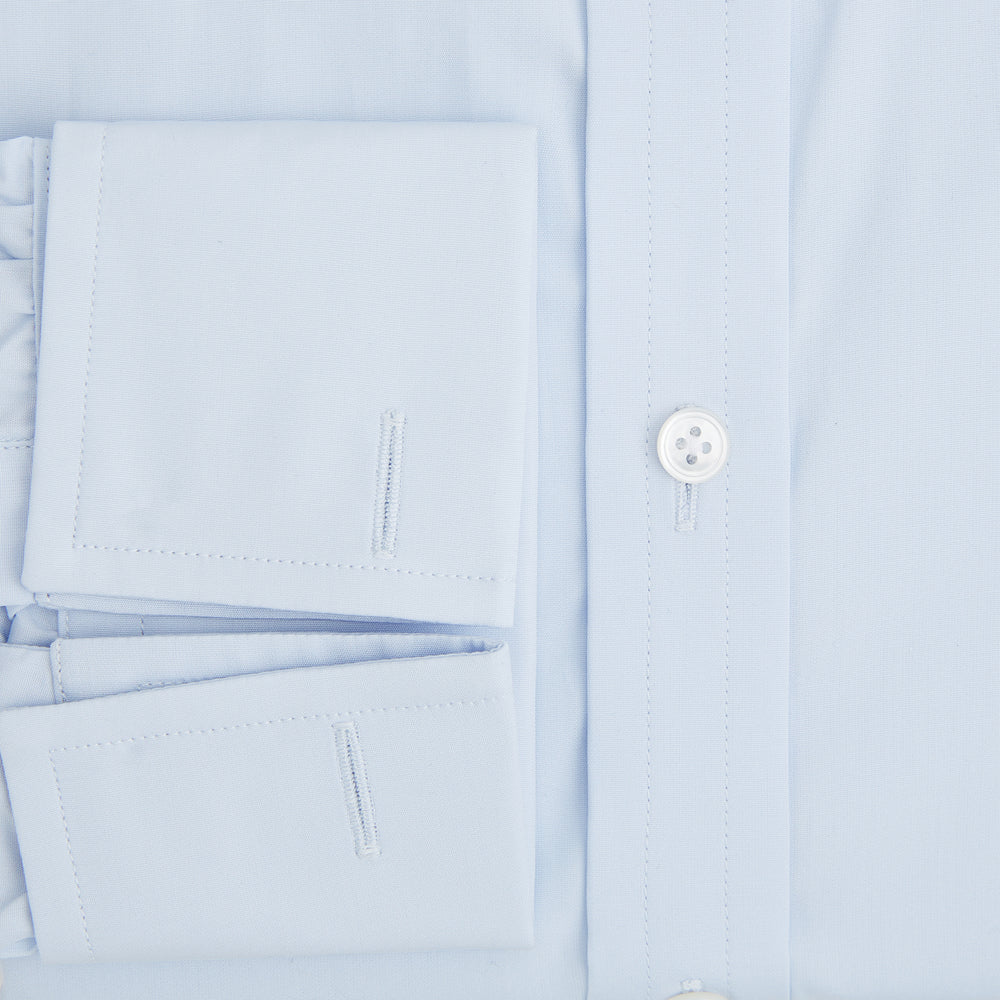 The Turnbull & Asser Light Blue Mayfair Shirt features white buttons, a classic collar, and buttoned cuffs—styled flat on a white background, it’s ideal for minimalist outfits or pairing with bold ties.