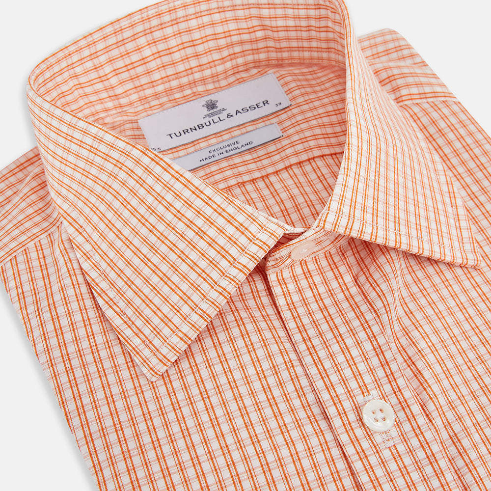 The Turnbull & Asser Orange Micro Check Mayfair Shirt, a long-sleeve button-up with a classic T&A collar and white-orange micro check pattern, is shown neatly laid flat on a white background.