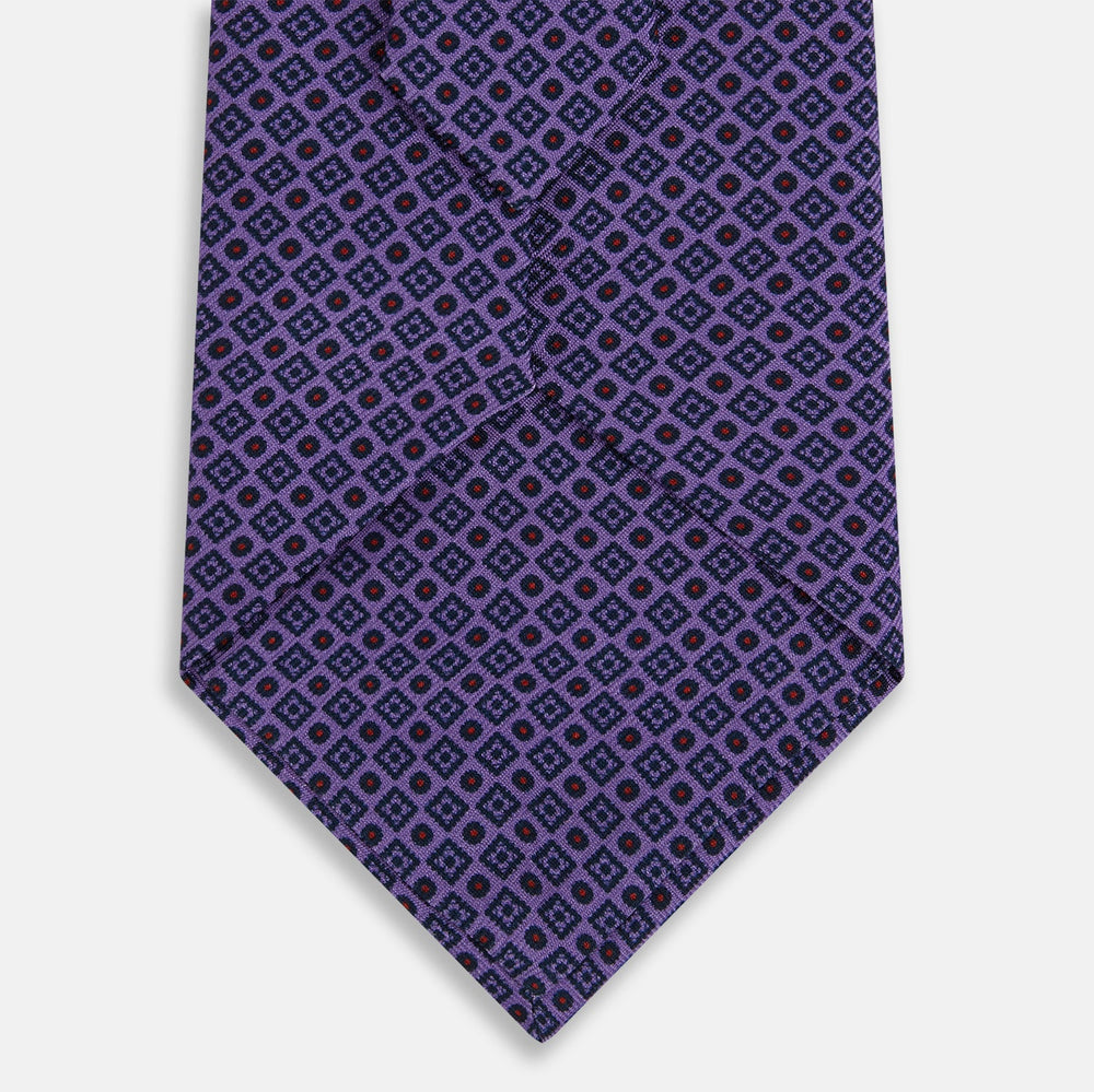 The Turnbull & Asser Purple Square and Circle Silk Tie is crafted from fine English silk, showcasing a purple design with a repeating geometric pattern of squares and circles for a refined, elegant look.