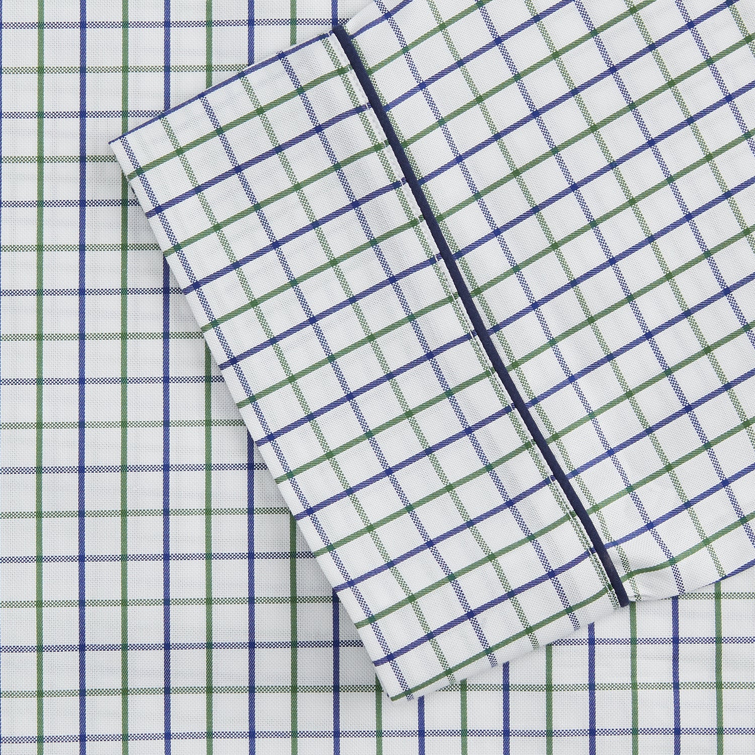 View 3 of product The Turnbull & Asser Green and Blue Check Cotton Hyde Pyjama Set for men features a long-sleeve, button-up top and pants with contrasting dark piping, shown laid flat on a white background.