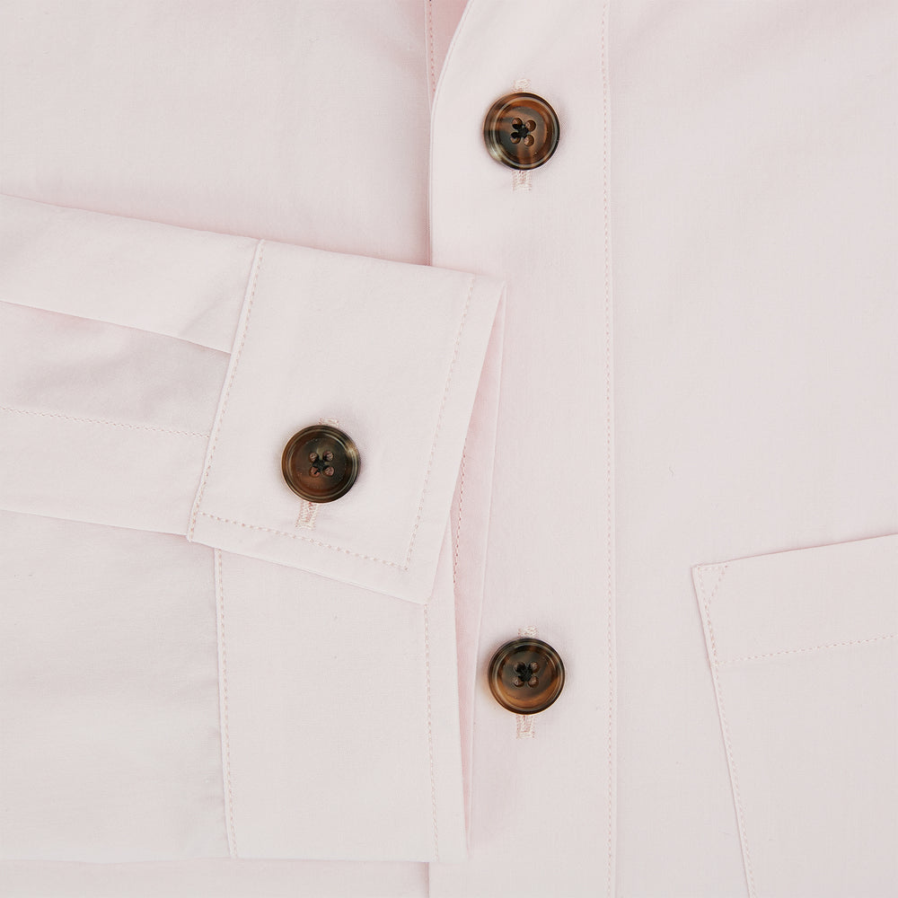 The Soft Pink Hyde Overshirt by Turnbull & Asser features long sleeves, sanforised cotton, dark buttons, and a left front pocket, shown laid flat on a white background.