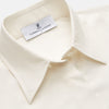 View 2 of product The Cream Silk Tailored Bianca Shirt by Turnbull & Asser features long sleeves, a pointed collar, and curved hem in soft-touch peace silk with a tailored fit. Shown laid flat on a white background.