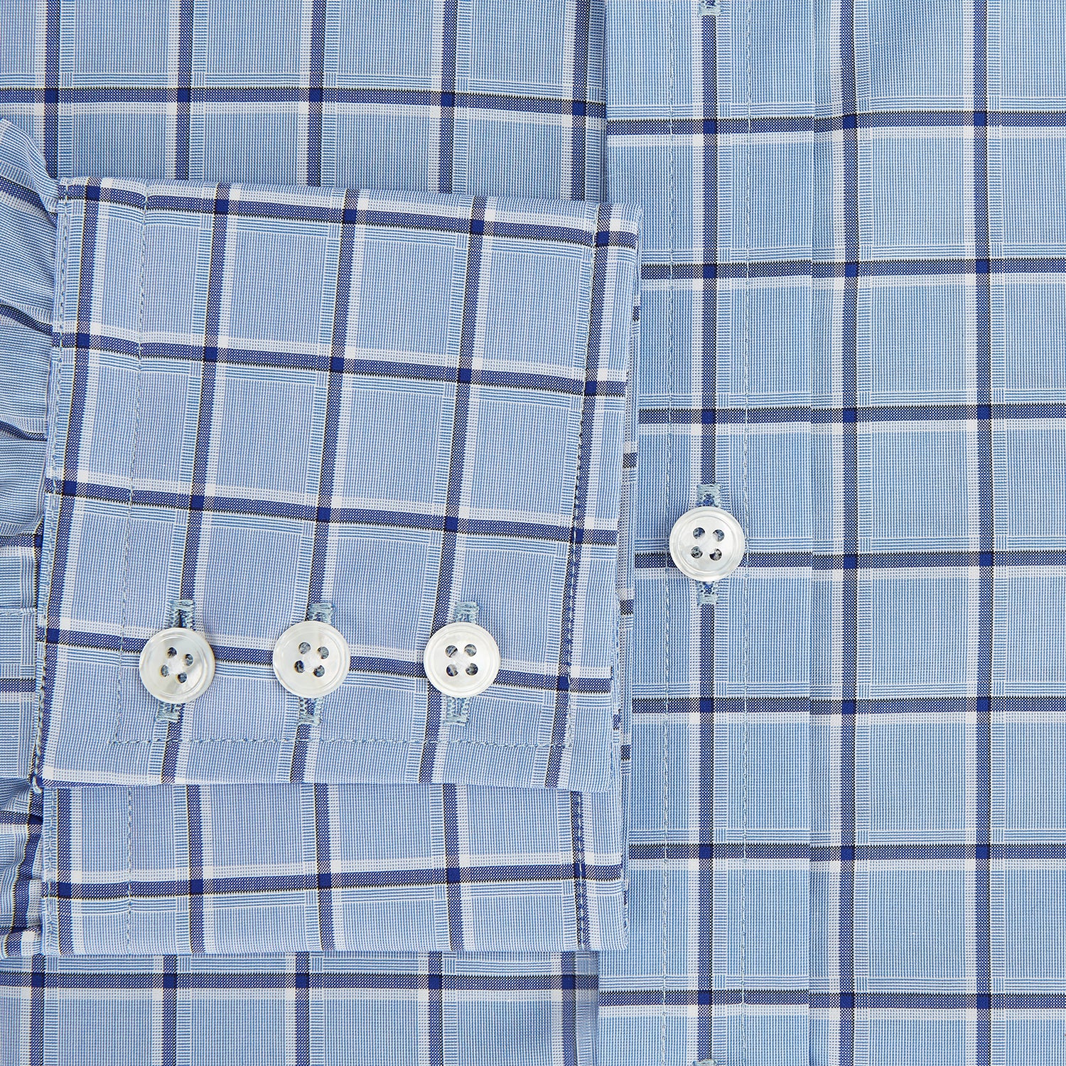 View 4 of product The Turnbull & Asser Blue and Navy Windowpane Mayfair Shirt features long sleeves, a T&A collar, buttoned cuffs, and Italian cotton in a blue and navy windowpane pattern, shown on a plain white background.