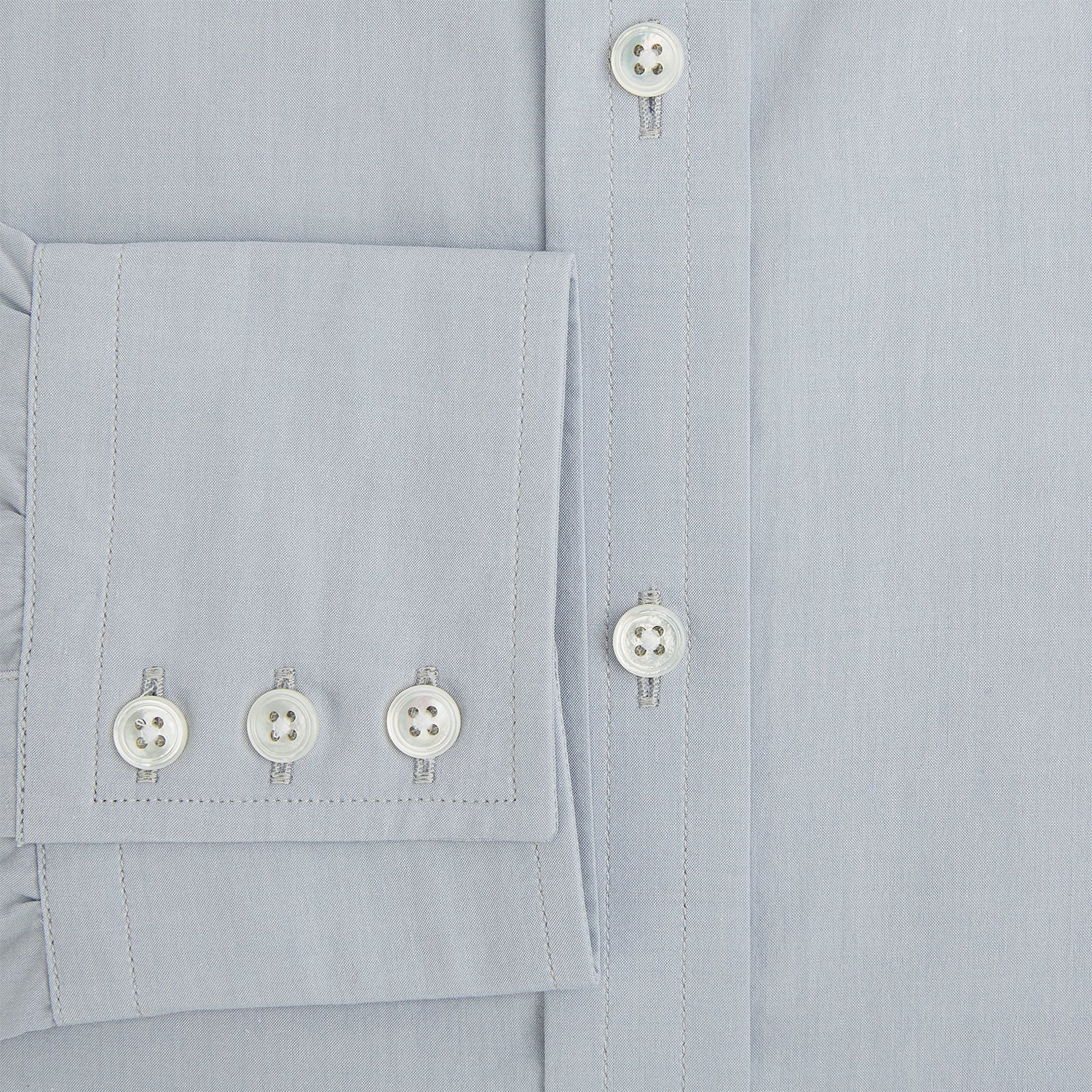 View 4 of product The Dove Grey Mayfair Shirt by Turnbull & Asser is a long-sleeve button-up with a collar, front pocket, and white buttons, crafted from soft sanforised cotton and laid flat on a white background.