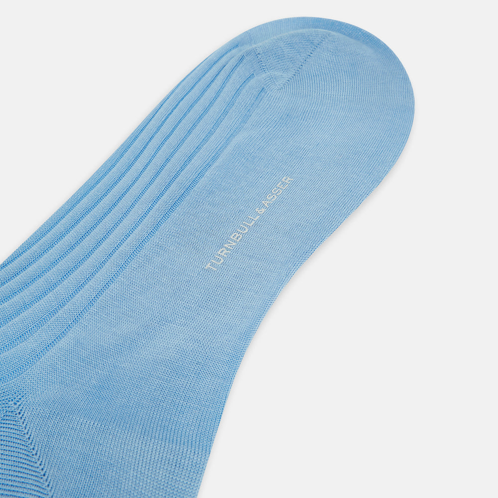 A single Turnbull & Asser Pale Blue Long Sock, featuring a ribbed texture and crafted from mercerised Egyptian cotton, is displayed upright on a plain white background.