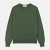 View 2 of product A man stands facing the camera against a plain light background, wearing the Turnbull & Asser Bottle Green Merino Kingston Crew Neck Jumper with dark pants and black shoes. His arms rest at his sides and he has a neutral expression.