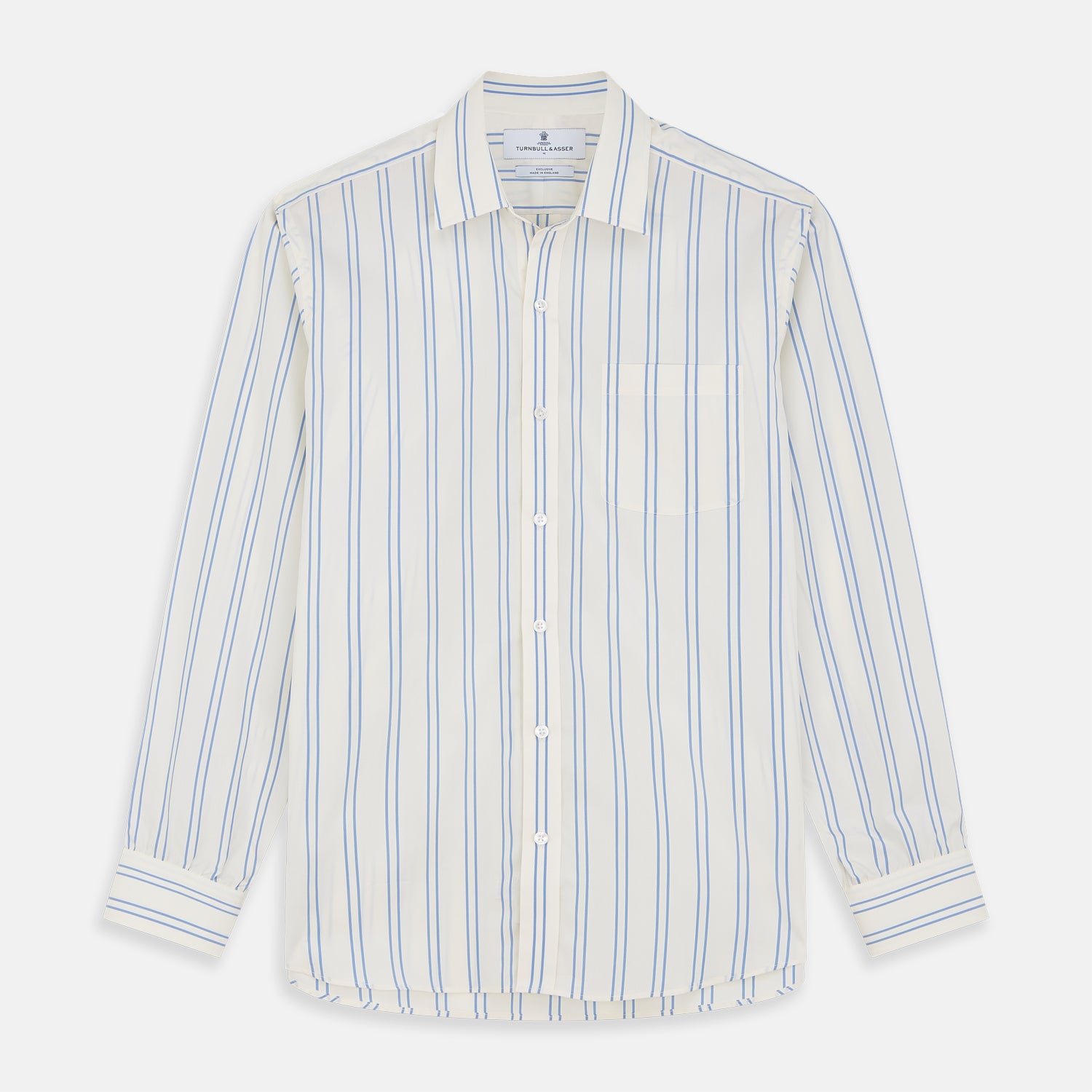 View 2 of product A man with short brown hair stands against a beige background in a Turnbull & Asser Blue and Off-White Stripe Cotton Weekend Fit Finch Shirt, featuring vertical stripes and a Derby collar, paired with dark pants. One hand is in his pocket; he has a neutral expression.