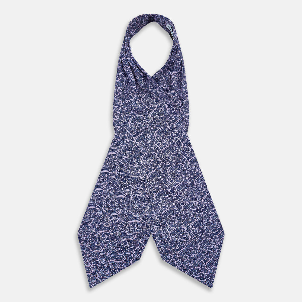 The Turnbull & Asser Lilac Paisley Silk Cravat showcases British elegance with its dark blue paisley pattern on a lilac background, beautifully displayed on a white surface.