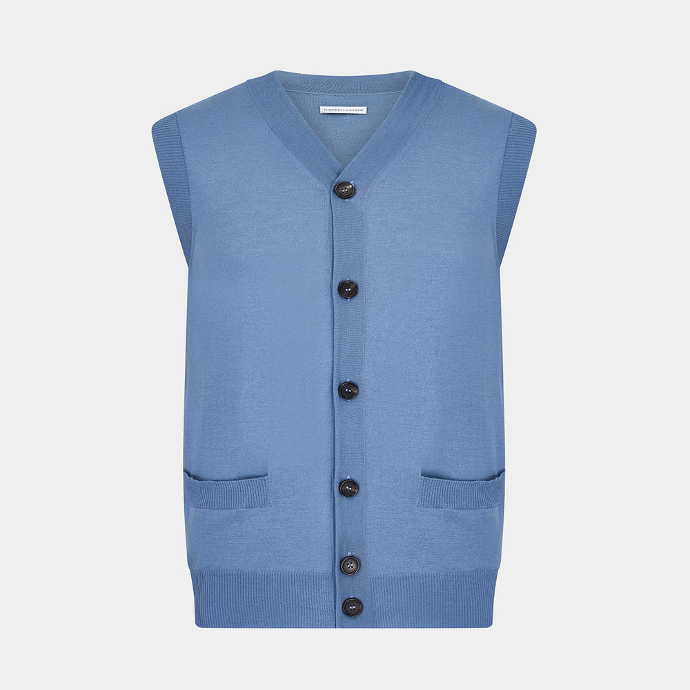 Turnbull & Asser’s Pale Blue Merino V-neck Sleeveless Cardigan features a button-up front, two pockets, and ribbed hem—a classic gentleman’s piece shown on a plain white background.