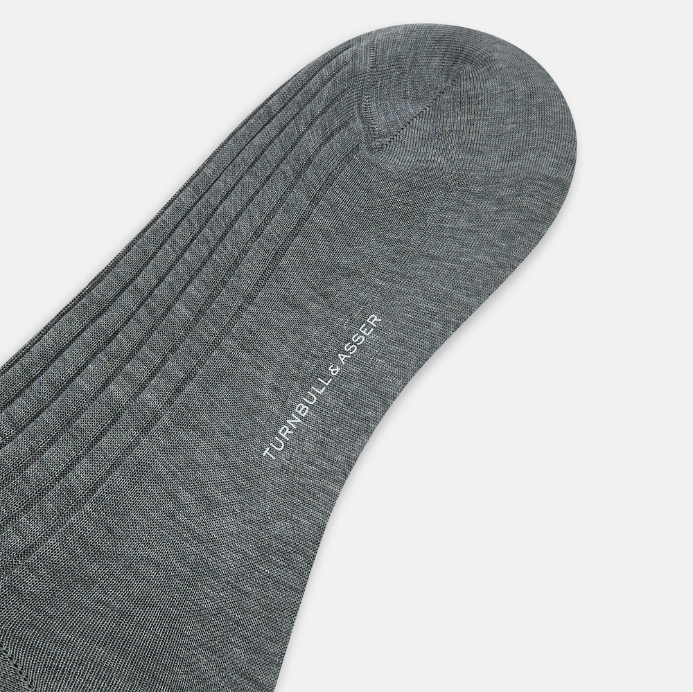 The Ash Mid-Length Sock by Turnbull & Asser, shown upright on a plain white background, is a single dark gray ribbed knee-high made from mercerised Egyptian cotton.