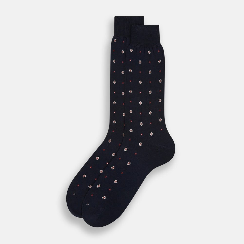 The Turnbull & Asser Midnight Patterned Mid-Length Sock features a ribbed cuff and a design of small white hexagons with red dots, shown here as a single sock on a plain white background.