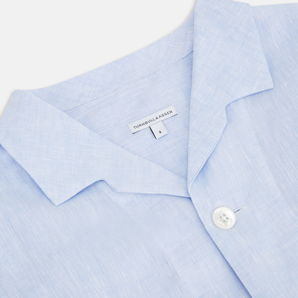 The Turnbull & Asser Pale Blue Linen Pyjama Shirt features long sleeves, a collar, front buttons, and a chest pocket—perfect as elegant loungewear or nightwear.