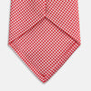 View 4 of product The Turnbull & Asser Red Houndstooth Silk Tie features a textured, small geometric pattern in red and white—ideal as a classic office accessory, shown rolled up on a plain white background.