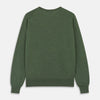 View 5 of product A man stands facing the camera against a plain light background, wearing the Turnbull & Asser Bottle Green Merino Kingston Crew Neck Jumper with dark pants and black shoes. His arms rest at his sides and he has a neutral expression.
