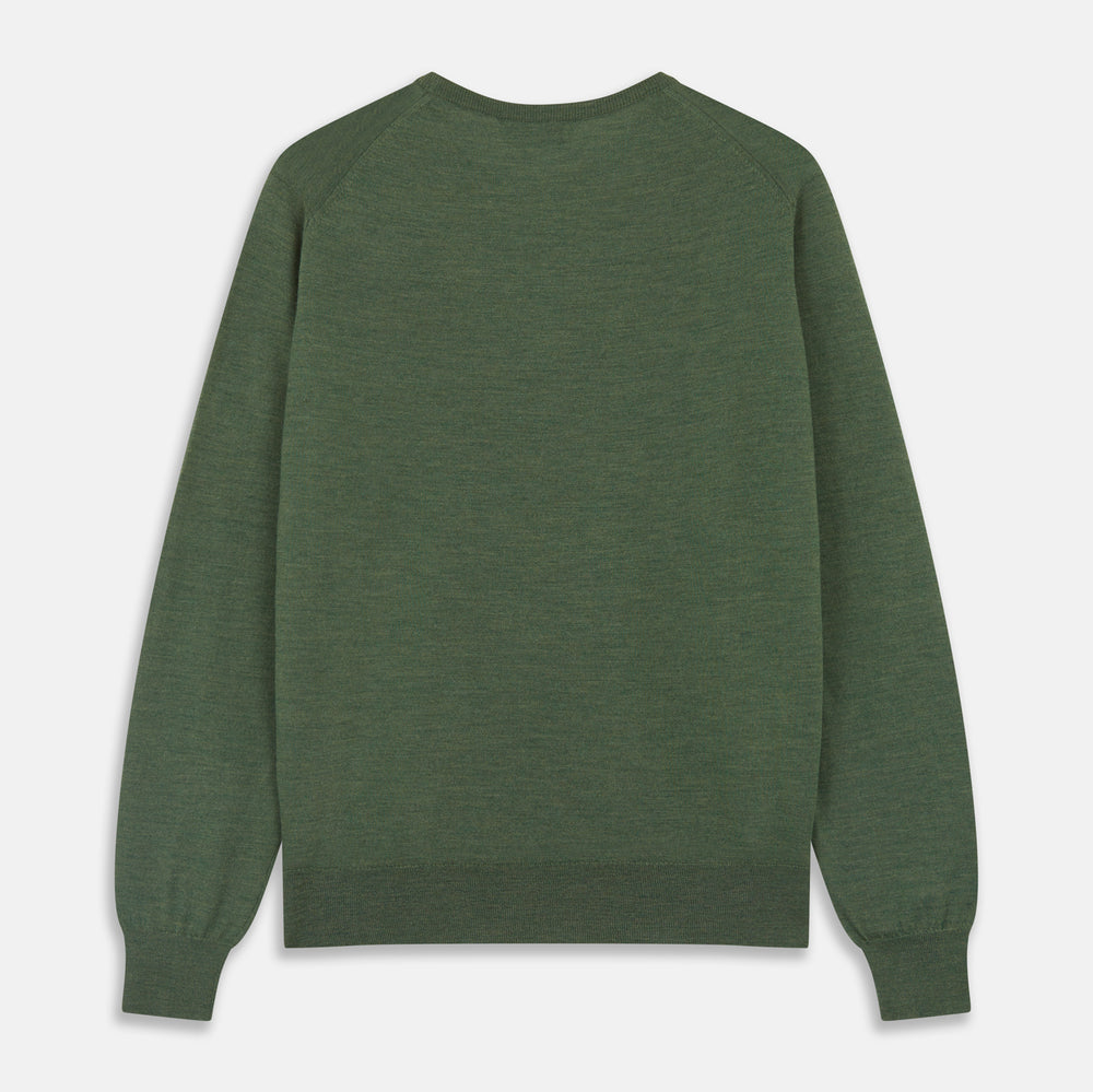 A man stands facing the camera against a plain light background, wearing the Turnbull & Asser Bottle Green Merino Kingston Crew Neck Jumper with dark pants and black shoes. His arms rest at his sides and he has a neutral expression.
