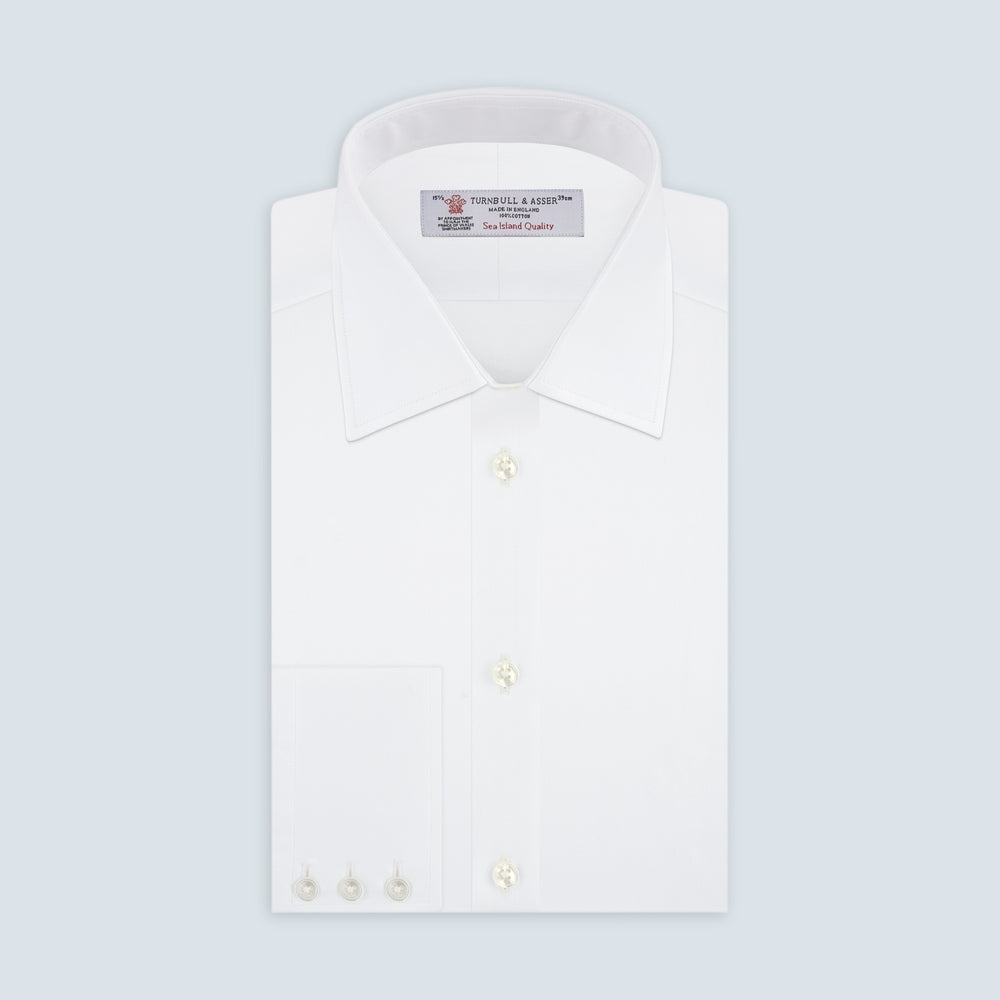 The Turnbull & Asser White Self-On-Self Herringbone Sea Island Quality Cotton Shirt features a T&A collar, 3-button cuffs, and luxurious Egyptian cotton, displayed neatly folded against a light gray background.