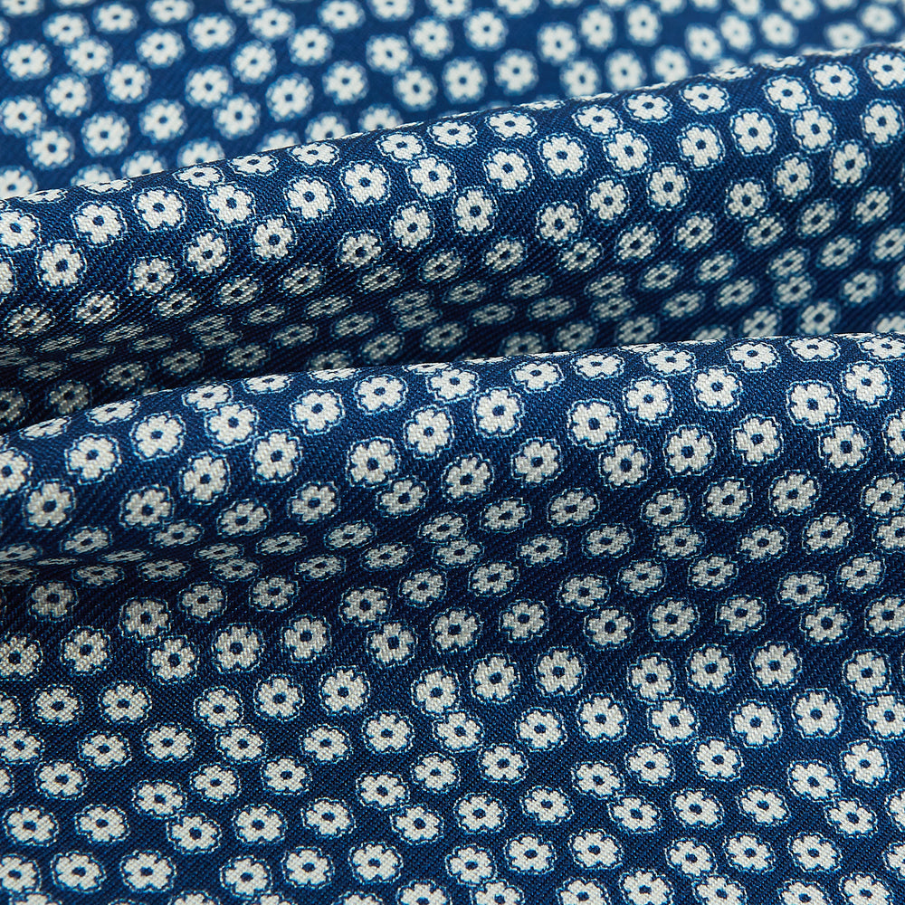 The Azzurro Flower Patterned Silk Cravat by Turnbull & Asser features a classic blue design with small white flowers—a refined British-inspired accessory.