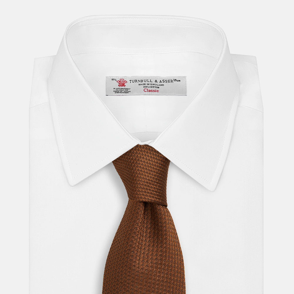 The Turnbull & Asser Plain Lace Jacquard Earth Tie, an essential brown wardrobe accessory, is shown rolled up against a plain white background.