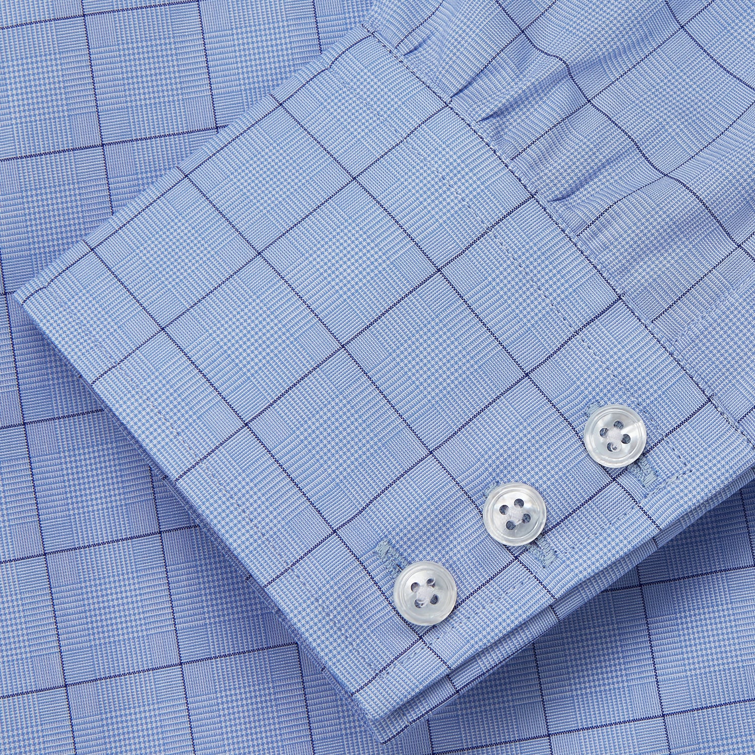 View 4 of product The Blue Prince of Wales Check Mayfair Shirt by Turnbull & Asser is a light blue formal long-sleeve shirt with a subtle check pattern, button-down front, and buttoned cuffs, shown laid flat on a white background.