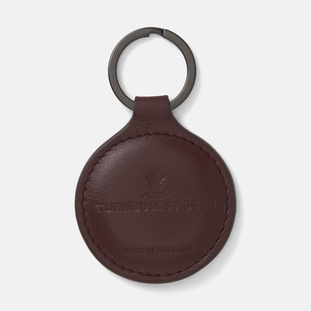 A burgundy leather fob holder by Turnbull & Asser, embossed with the brand name and Made in England, features a metal split keyring at the top.