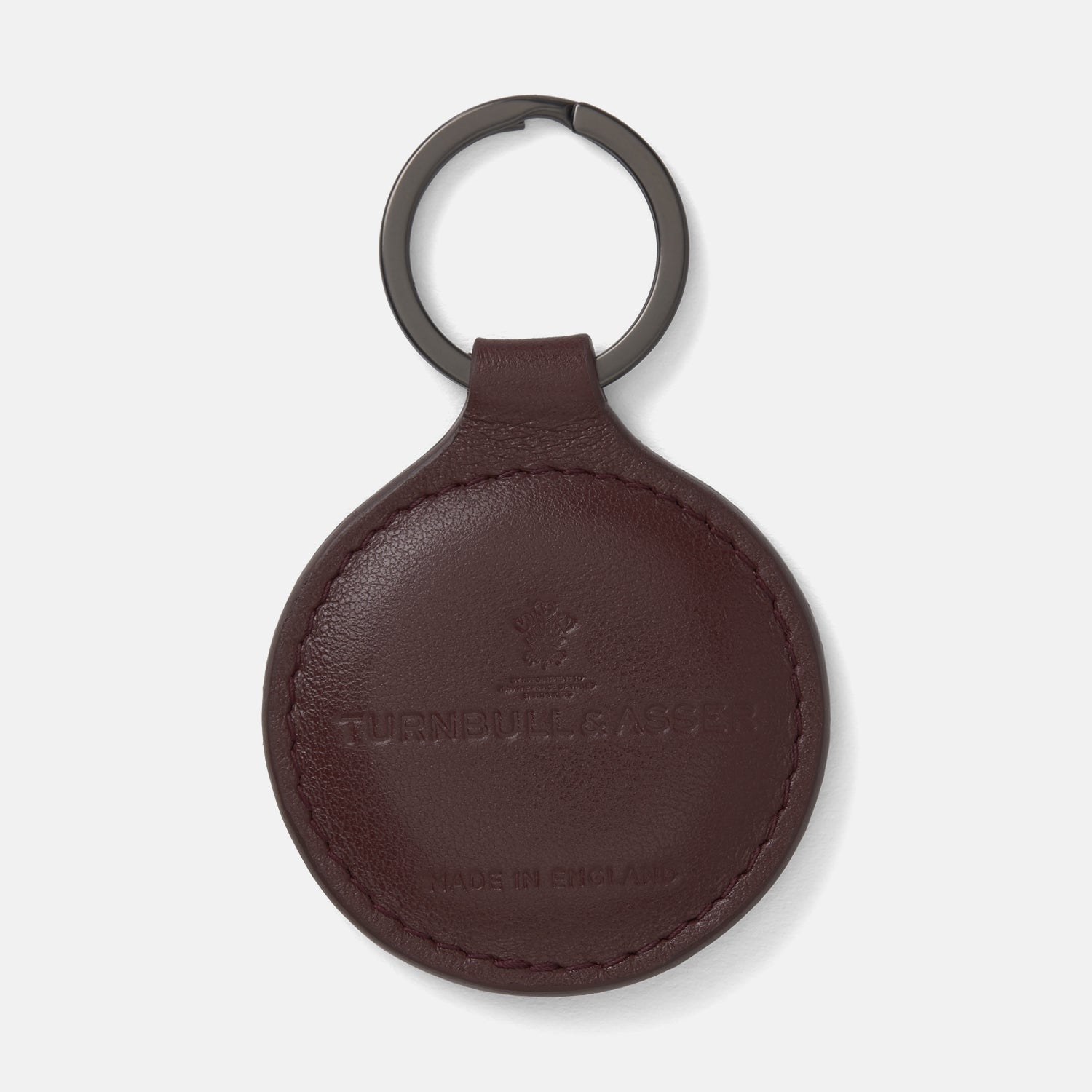 View 1 of product A burgundy leather fob holder by Turnbull & Asser, embossed with the brand name and Made in England, features a metal split keyring at the top.