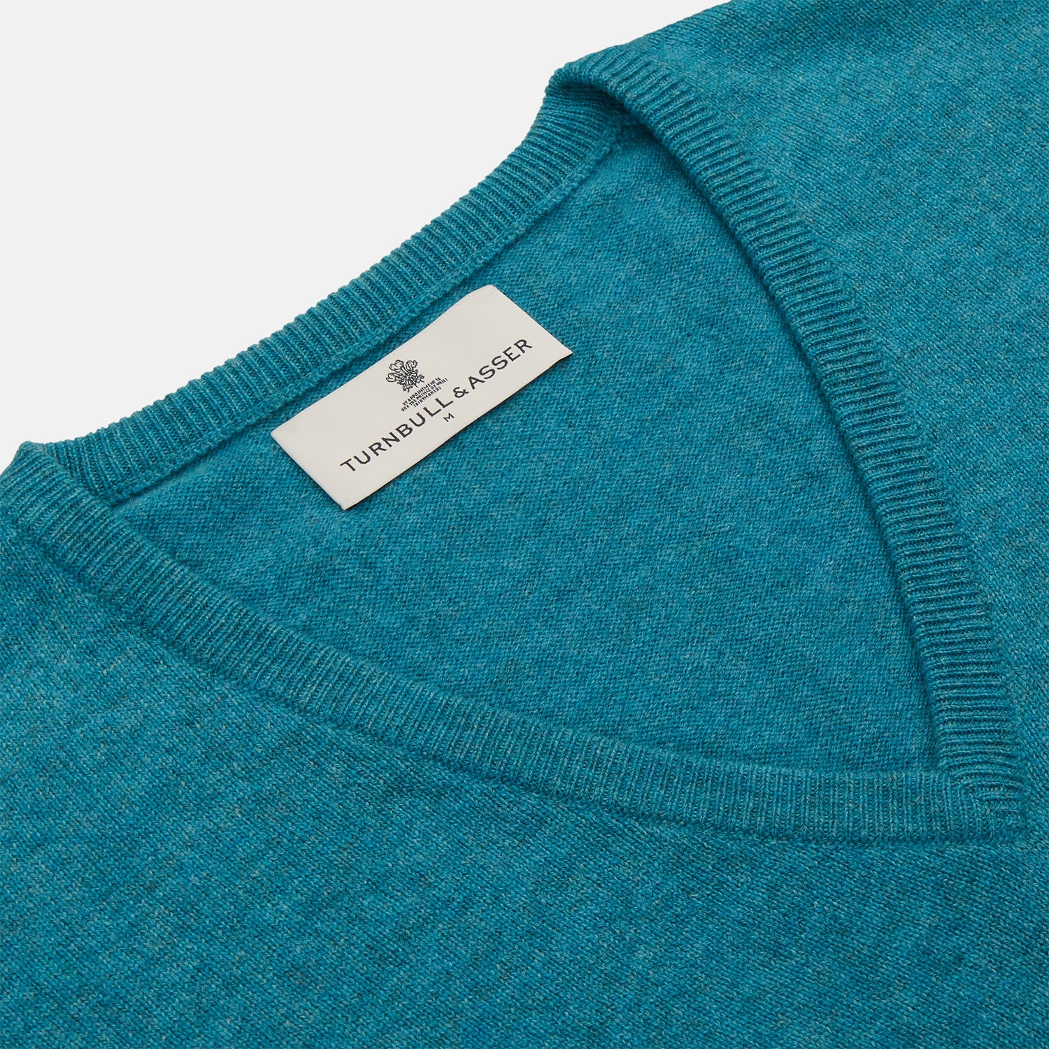 View 2 of product The Teal Ifor Slipover by Turnbull & Asser is a sleeveless, V-neck knit made in Scotland from lightweight cashmere, shown in teal blue against a white background.