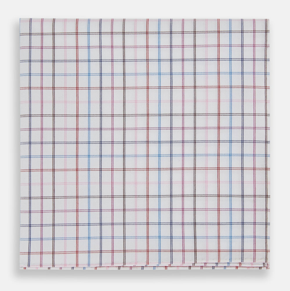 The Turnbull & Asser Hand Rolled Multi Graph Check Handkerchief features a white cotton base with thin red, blue, and purple intersecting lines forming a check pattern, neatly folded with stitched edges for an elegant gentleman's accessory.