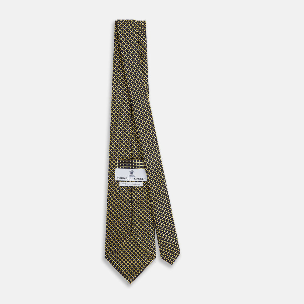 The Turnbull & Asser Yellow and Navy Diamond Silk Tie, with a refined yellow and light blue grid pattern, is elegantly rolled up on a plain white background.
