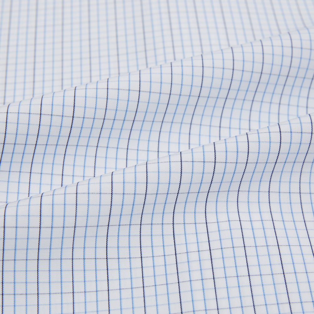 The Turnbull & Asser Pale Blue and Navy Grid Check Mayfair Shirt is a long-sleeve, button-up shirt made from fine Italian cotton, featuring a pointed collar and buttoned cuffs, shown against a plain white background.