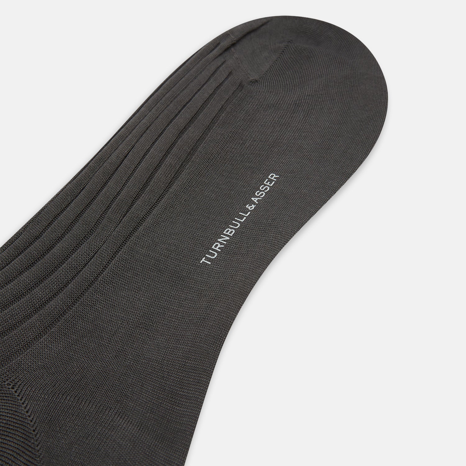 View 3 of product A single Concrete Grey Long Sock by Turnbull & Asser, featuring an over the calf fit and ribbed texture, is displayed on a plain white background.