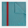 View 1 of product The Turnbull & Asser Turquoise and Red Stripe Silk Pocket Square features thin navy stripes with a bold vertical red stripe, partially folded to reveal the reverse pattern and the brand's logo, showcasing its British heritage.
