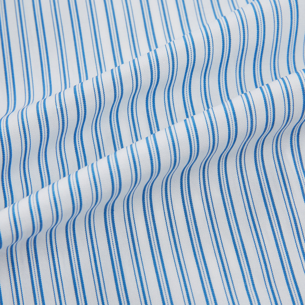 The Turnbull & Asser Sky Blue Double Stripe Mayfair Shirt features sky blue and white vertical stripes, a T&A collar, buttoned cuffs, and is displayed flat on a white background.