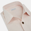 View 2 of product The Turnbull & Asser Pale Pink Hyde Overshirt is a long-sleeve, sanforised cotton button-up with a left chest pocket and dark buttons, shown laid flat on a white background.