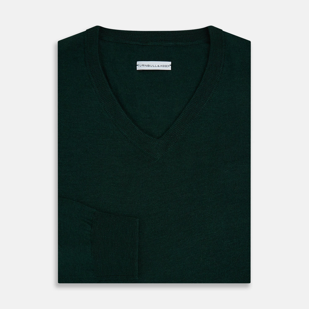The Turnbull & Asser Forest Green Fine Merino V-Neck Jumper features long sleeves, ribbed cuffs and hem—classic knitwear for any wardrobe, shown on a white background.